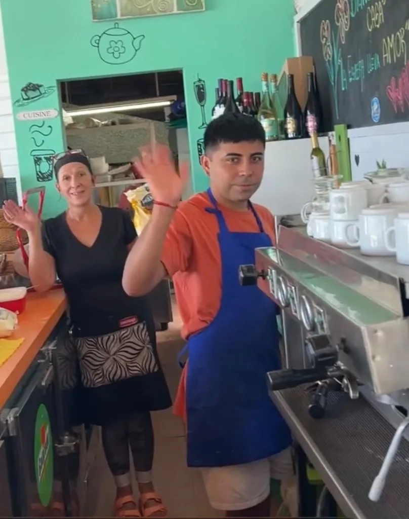 El equipo de barra y mozos saludando junto a la cafetera del Restó
