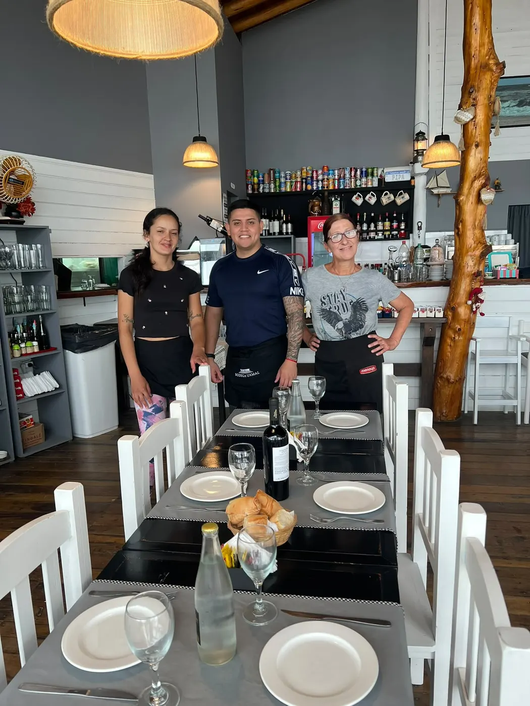 Los mozos del Restó en el salón con las mesas preparadas